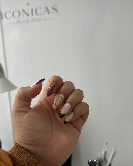 Uñas con diseño frente al logo del salón